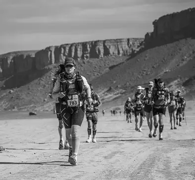 A group of people running a desert marathon