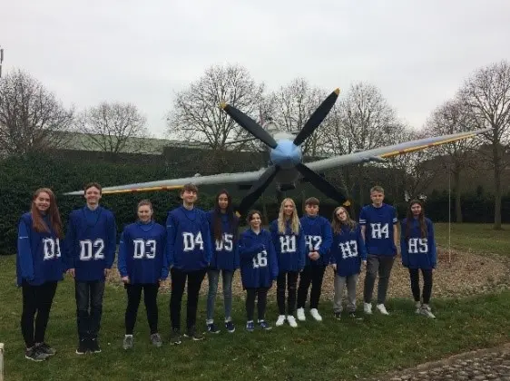 A group of Jon Egging Trust student in front of a plane